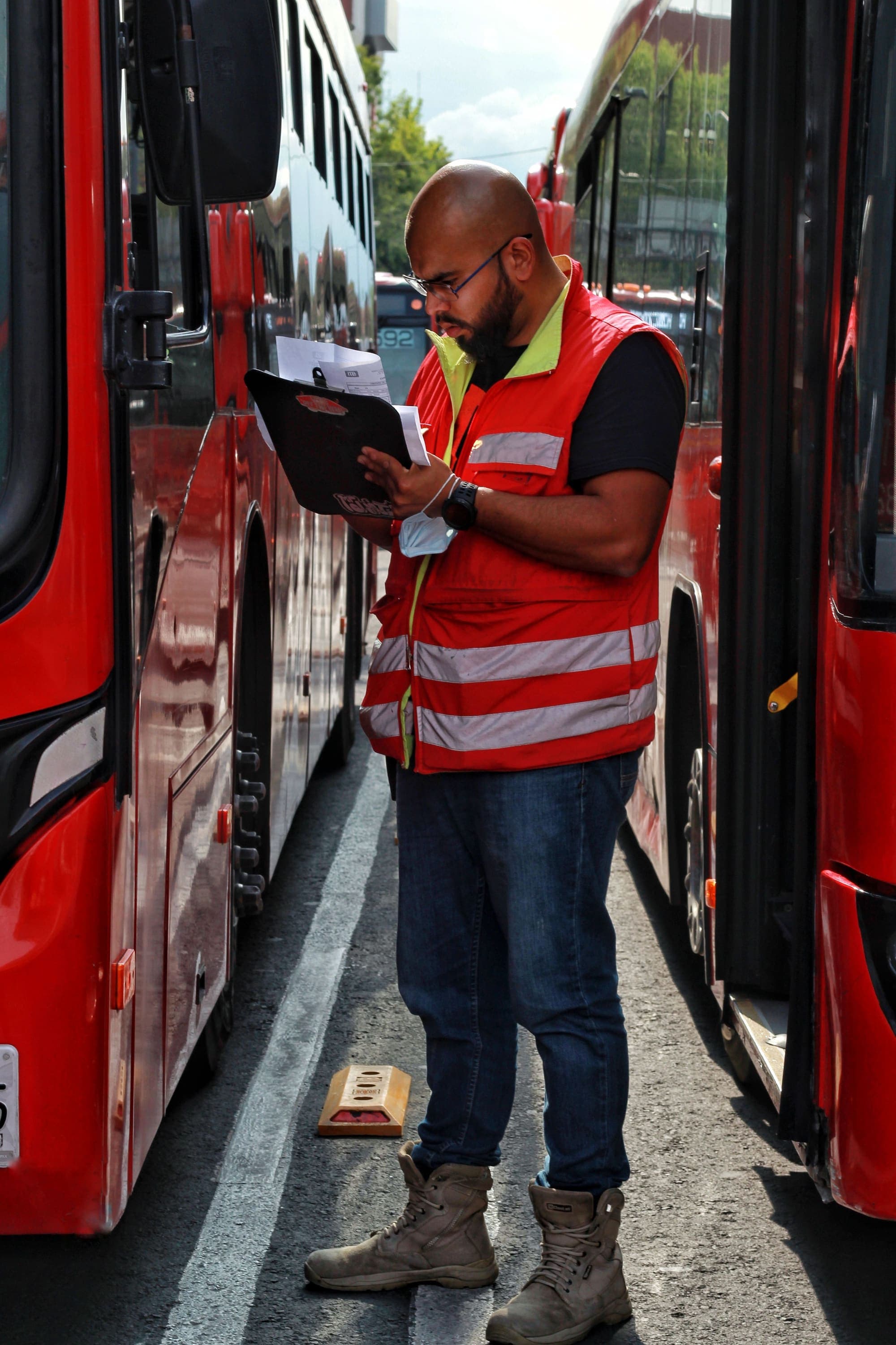 Field engineer inspecting vehicles in a working fleet environment.